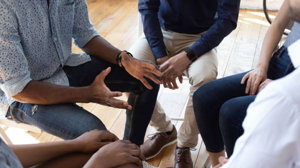 Individuals participating in group therapy during addiction recovery treatment